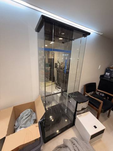Illuminated glass curio cabinet, second of the pair